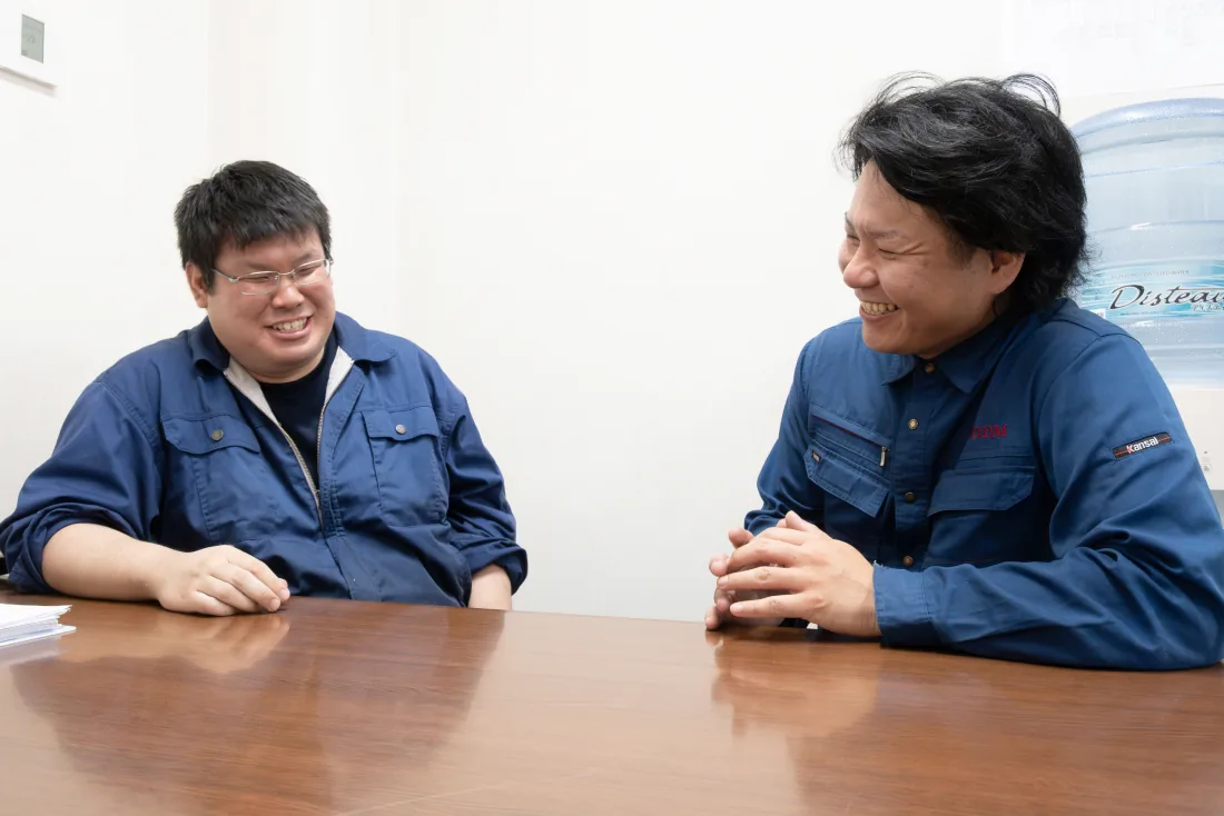 笑顔で談笑する2人の社員